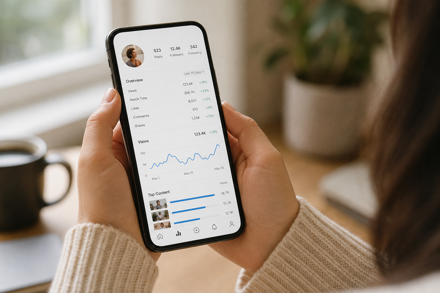 Hands holding a smartphone showing creator audience analytics used in influencer campaign management