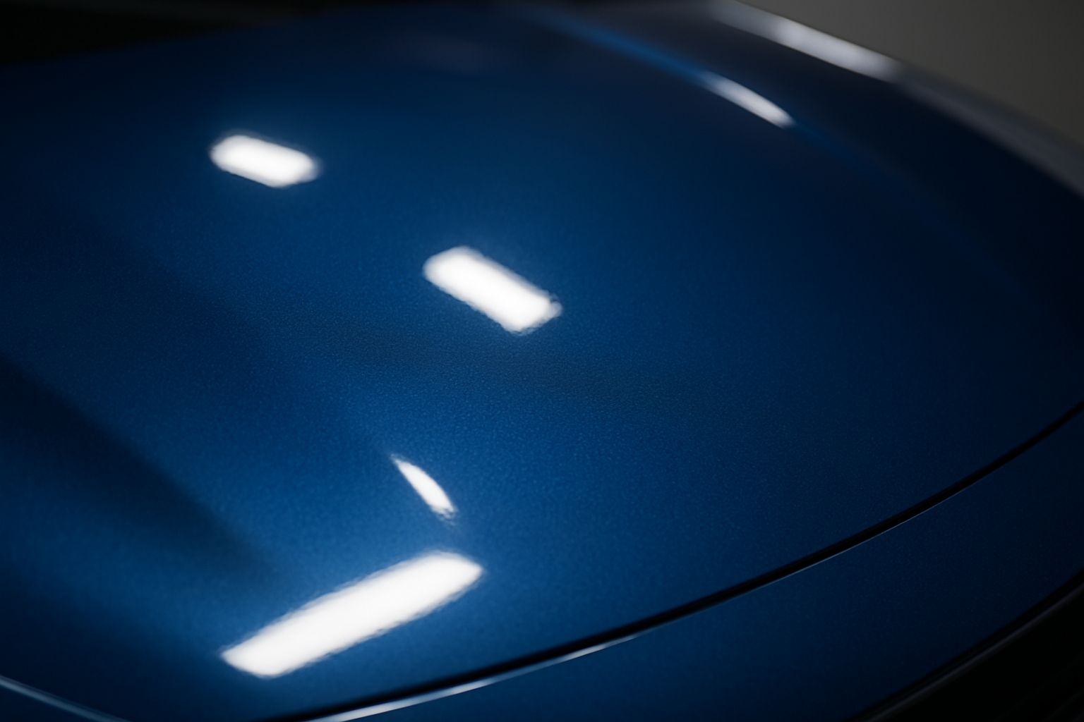 Freshly resprayed car hood with flawless metallic blue finish after a professional auto paint job