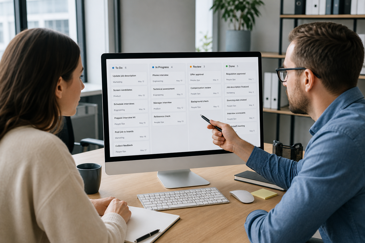 Office team reviewing job and contract status on a computer screen
