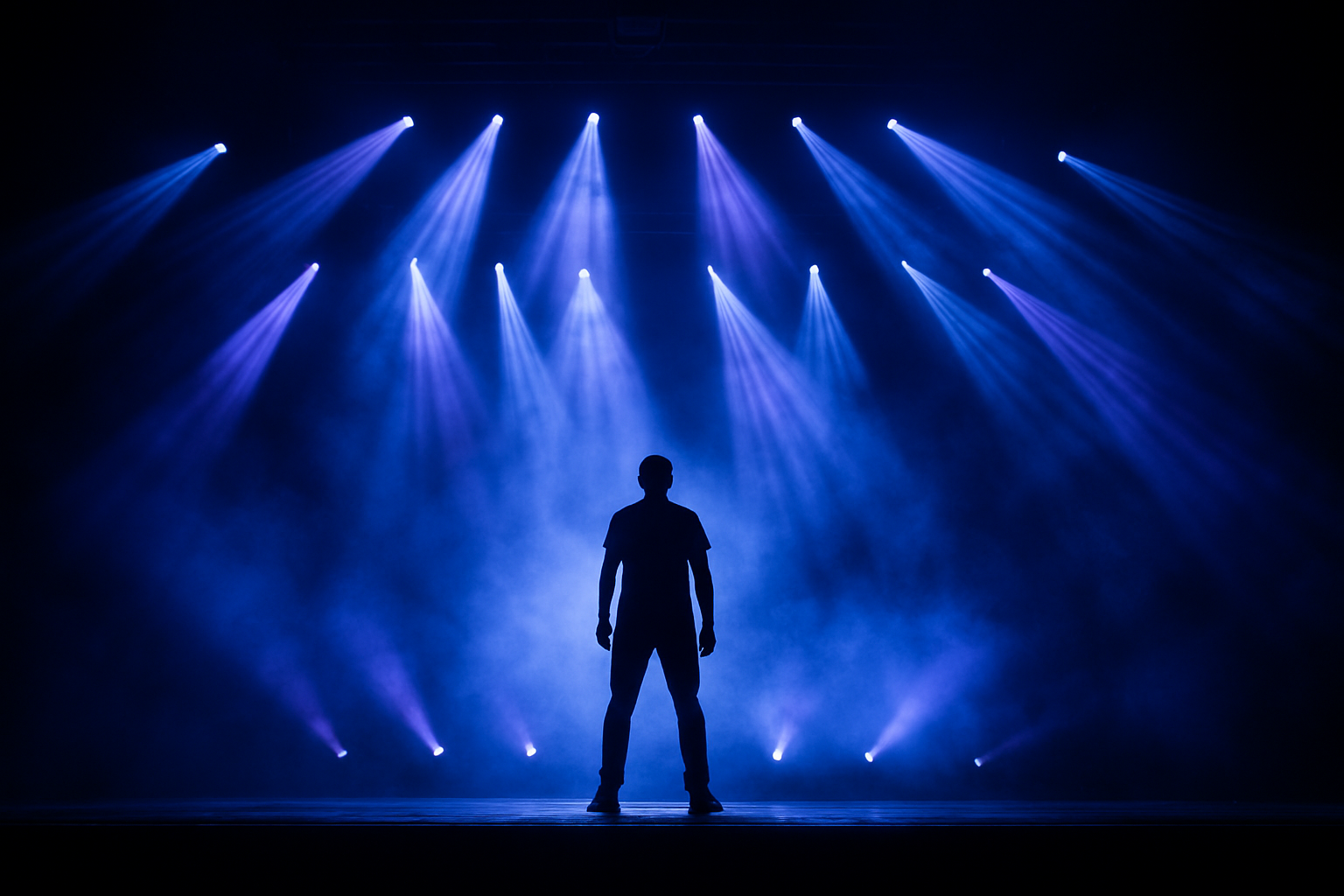 Live performance lighting with blue and purple moving head beams illuminating a concert stage