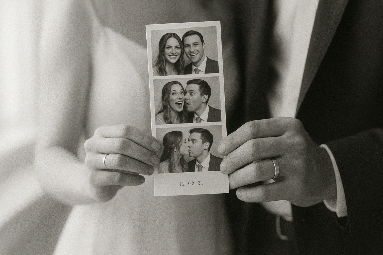 Bride and groom holding a printed black and white wedding photo keepsake from a booth