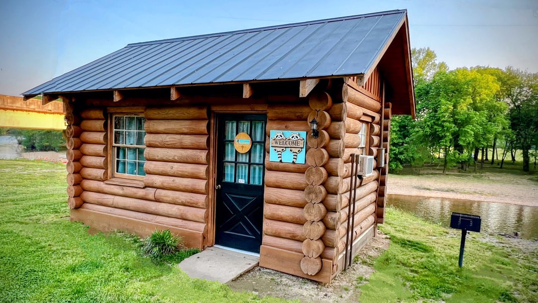 Small wooden riverfront cabin with a porch overlooking the Buffalo River